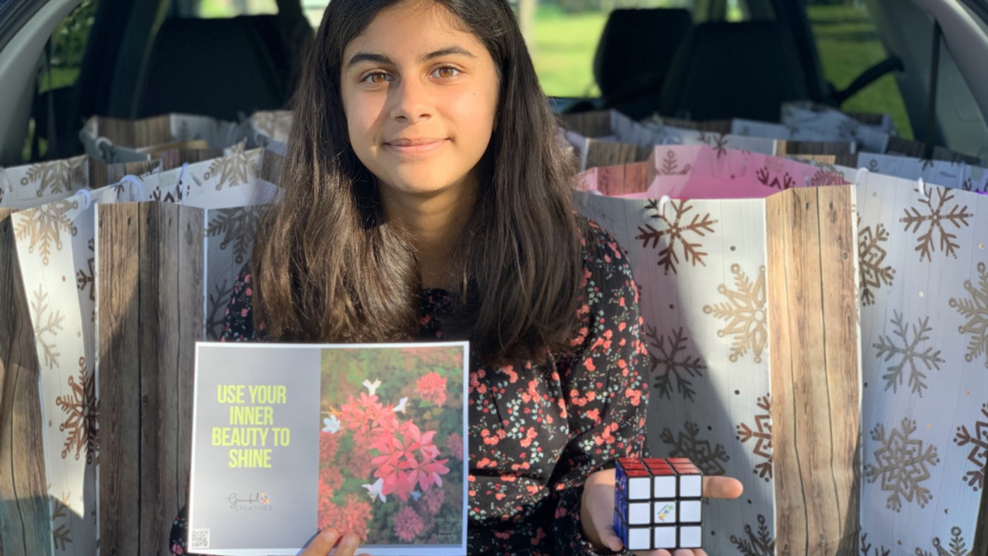 Inaya in front of her care packages for families experiencing cancer. Inaya is a Bleuet Girl entrepreneur