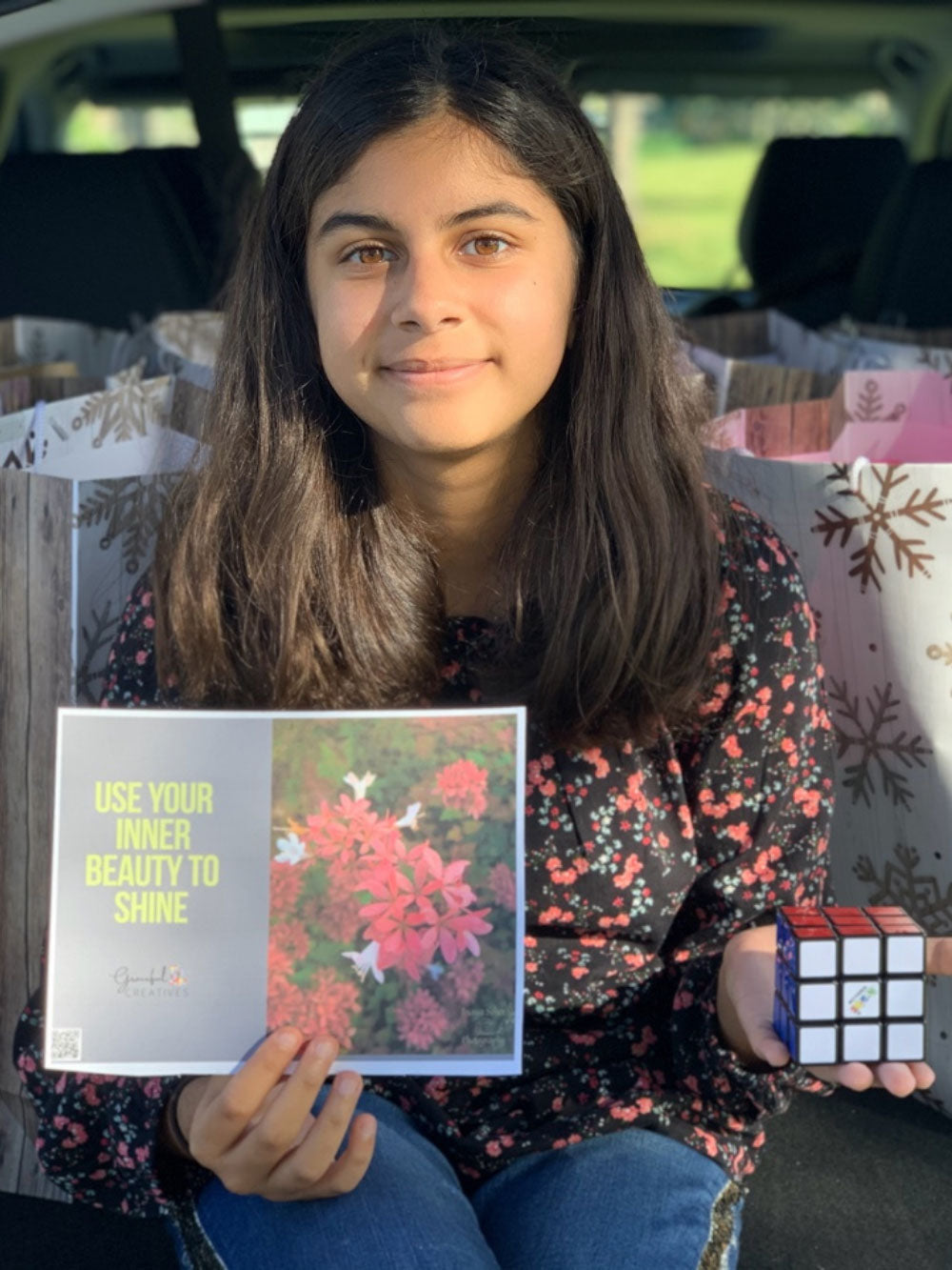 Inaya in front of her care packages for families experiencing cancer. Inaya is a Bleuet Girl entrepreneur