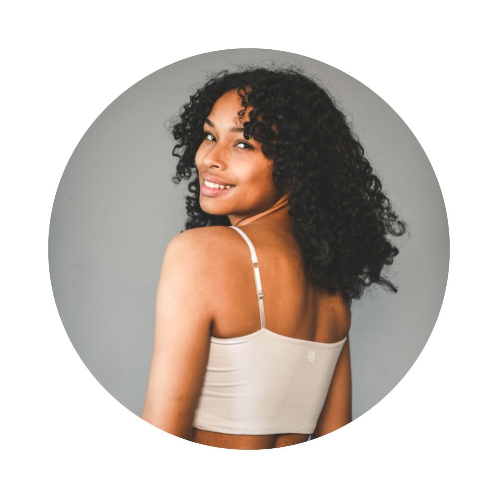 White-Dove#A girl with curly hair wearing a dove cami bra, viewed from the back.