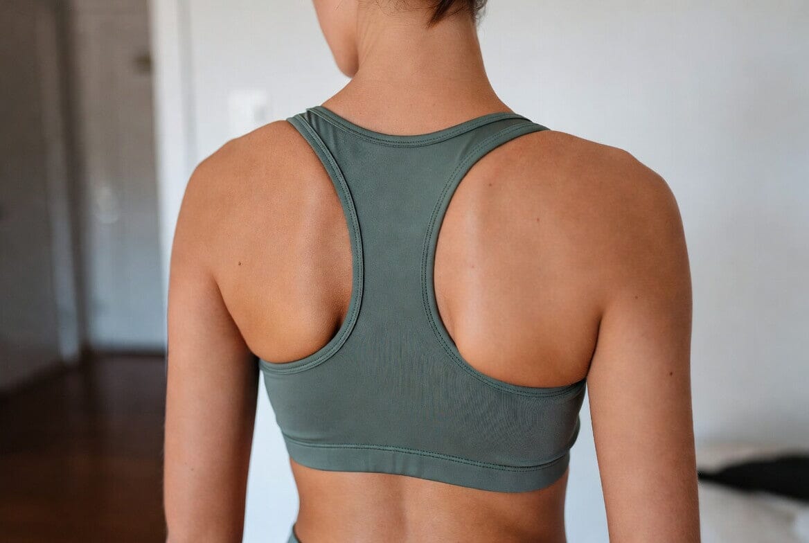 Close-up back view of a girl wearing a comfortable sage green wireless sports bra, showing the racerback design and fit.