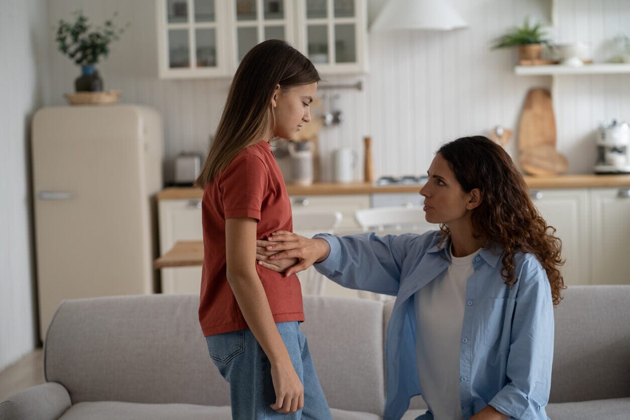 An image of a young girl complaining to her mother about a stomach ache.