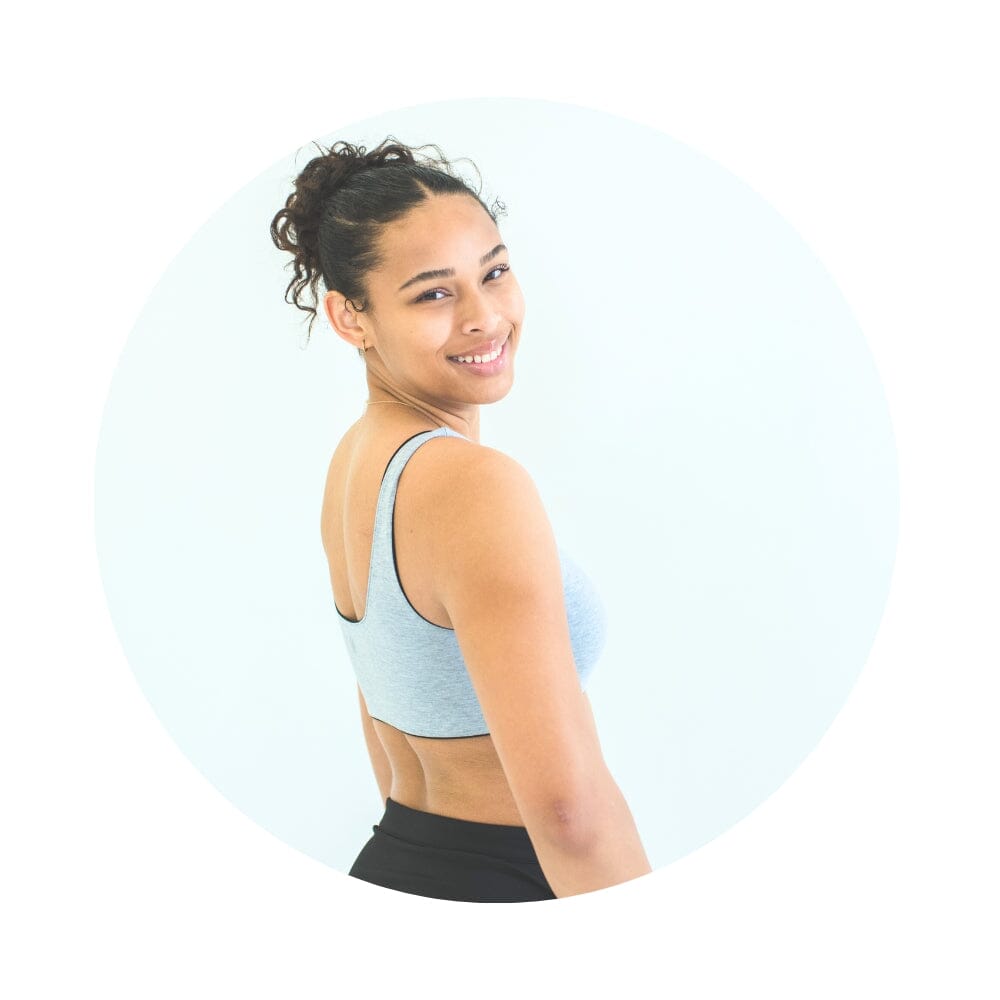 Black-Grey#A girl wearing a grey Aster Organic Tank Bra from Bleuet. She is facing backward and smiling over her shoulder. Black-Grey#Organic Bras & Bralettes For Girls, Tweens and Teens