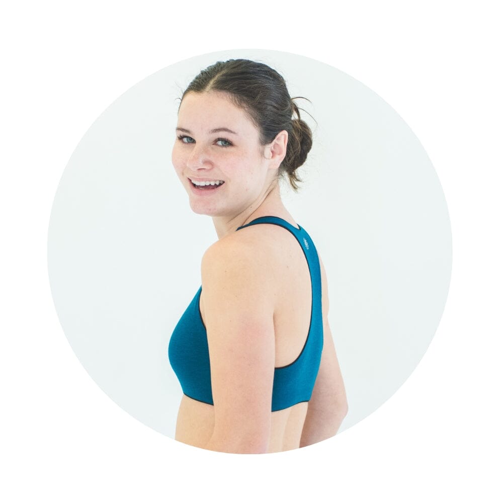 Black-Teal#A young woman with and looking over her shoulder, wearing a teal racerback bra.