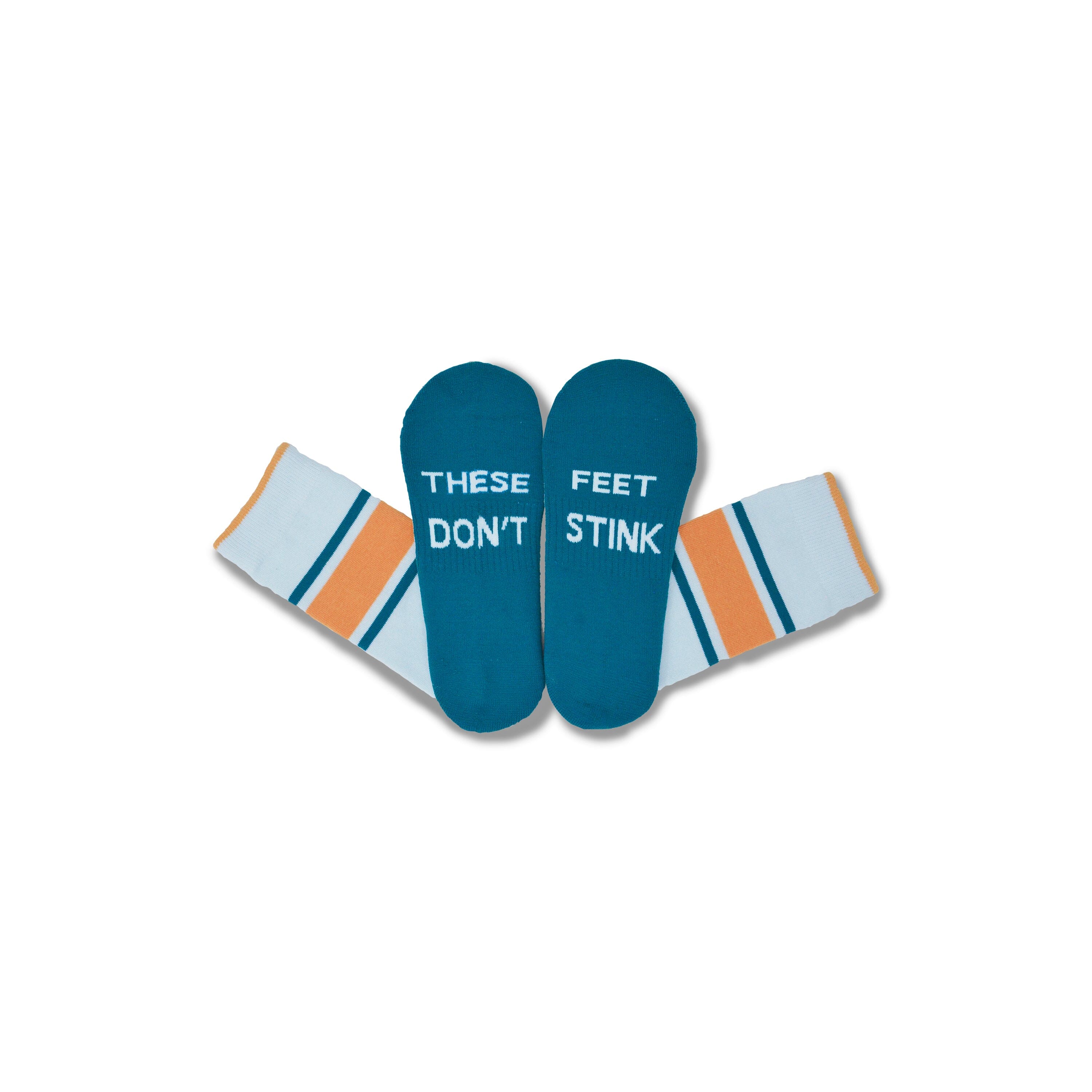 A pair of novelty socks with teal foot-shaped tops that read 'THESE FEET DON'T STINK' in white text, and cuffs in white with orange and teal stripes, shown on a plain white background.