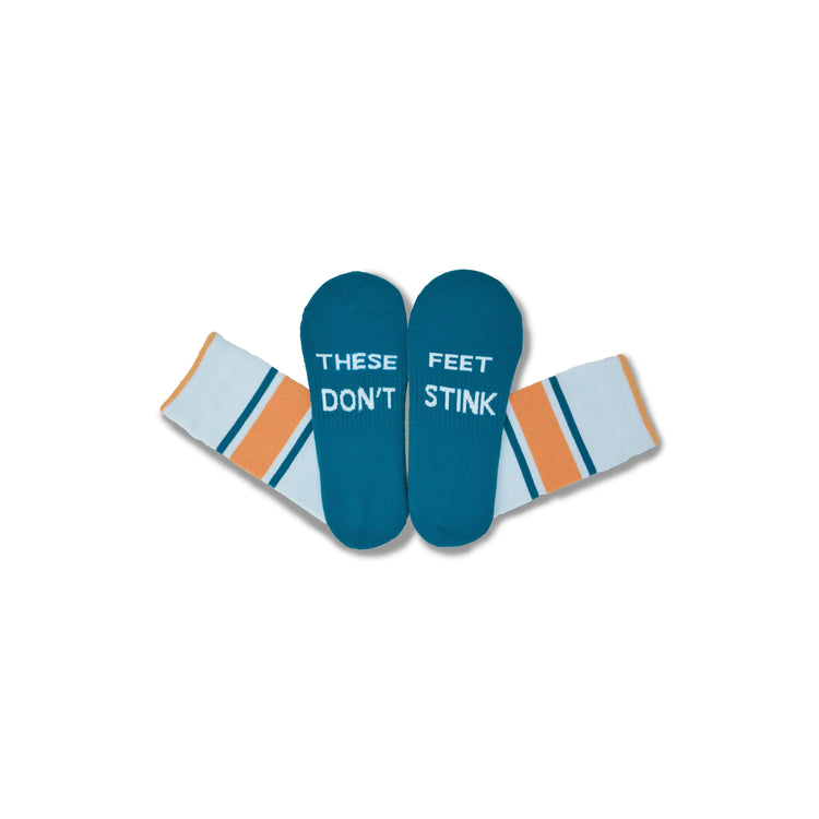 A pair of novelty socks with teal foot-shaped tops that read 'THESE FEET DON'T STINK' in white text, and cuffs in white with orange and teal stripes, shown on a plain white background.
