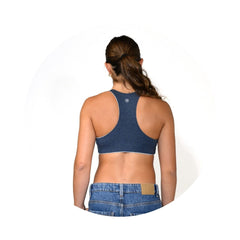 Grey-Lake#A woman shown from the back wearing a dark blue racerback sports bra and blue denim jeans against a plain white background.