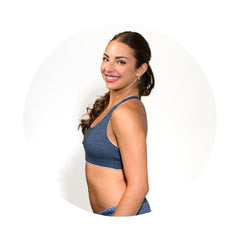 Grey-Lake#A woman with dark hair tied back is shown from the side wearing a heathered blue sports bra, set against a white circular background.