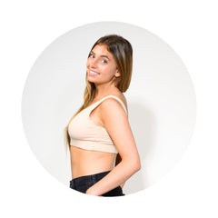 Sand-Rose# A young woman with brown hair smiling and looking over her shoulder, wearing an Sand-Rosecolor aster organic tank bra. 