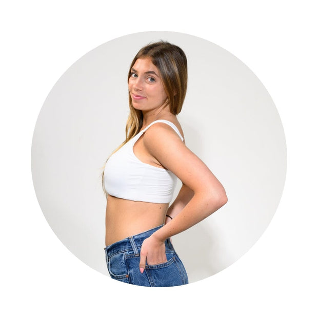 White#A woman posing in a white ribbed crop top and blue jeans, framed within a circular graphic on a white background.