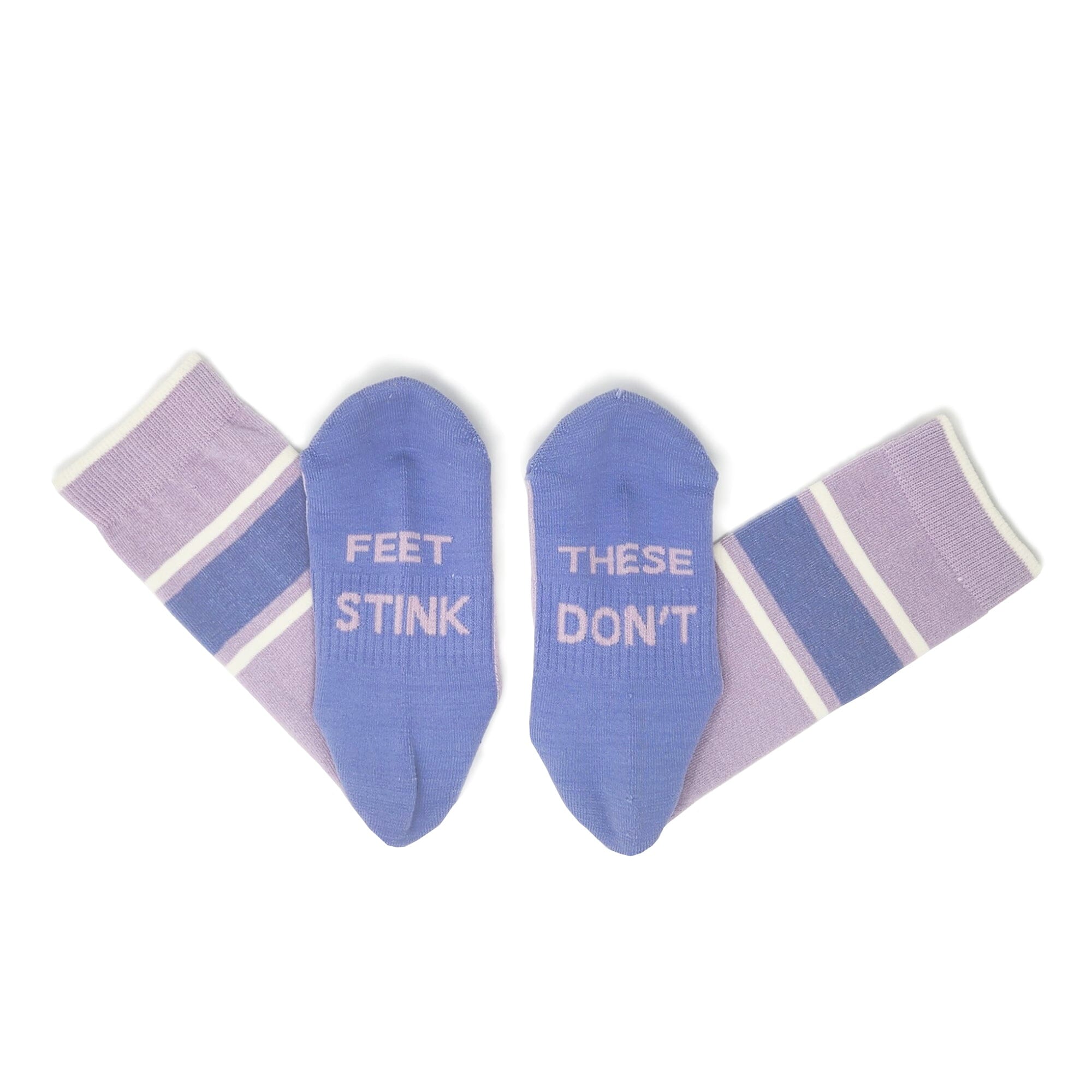 Lilac#A pair of novelty socks laid flat on a white background. The soles are a medium periwinkle blue with white text reading 'FEET STINK' and 'THESE DON'T', while the cuffs are lavender with white and dark blue stripes.
