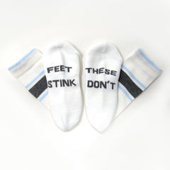 White#Two white ankle socks arranged in a fan shape on a white background. Two socks read 'FEET STINK' and two read 'THESE DON'T' in black text.
