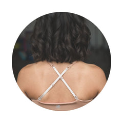 Caramel-Persimmon#Close-up back view of a person with shoulder-length hair wearing a beige Bleum Active Bra with crisscross straps.