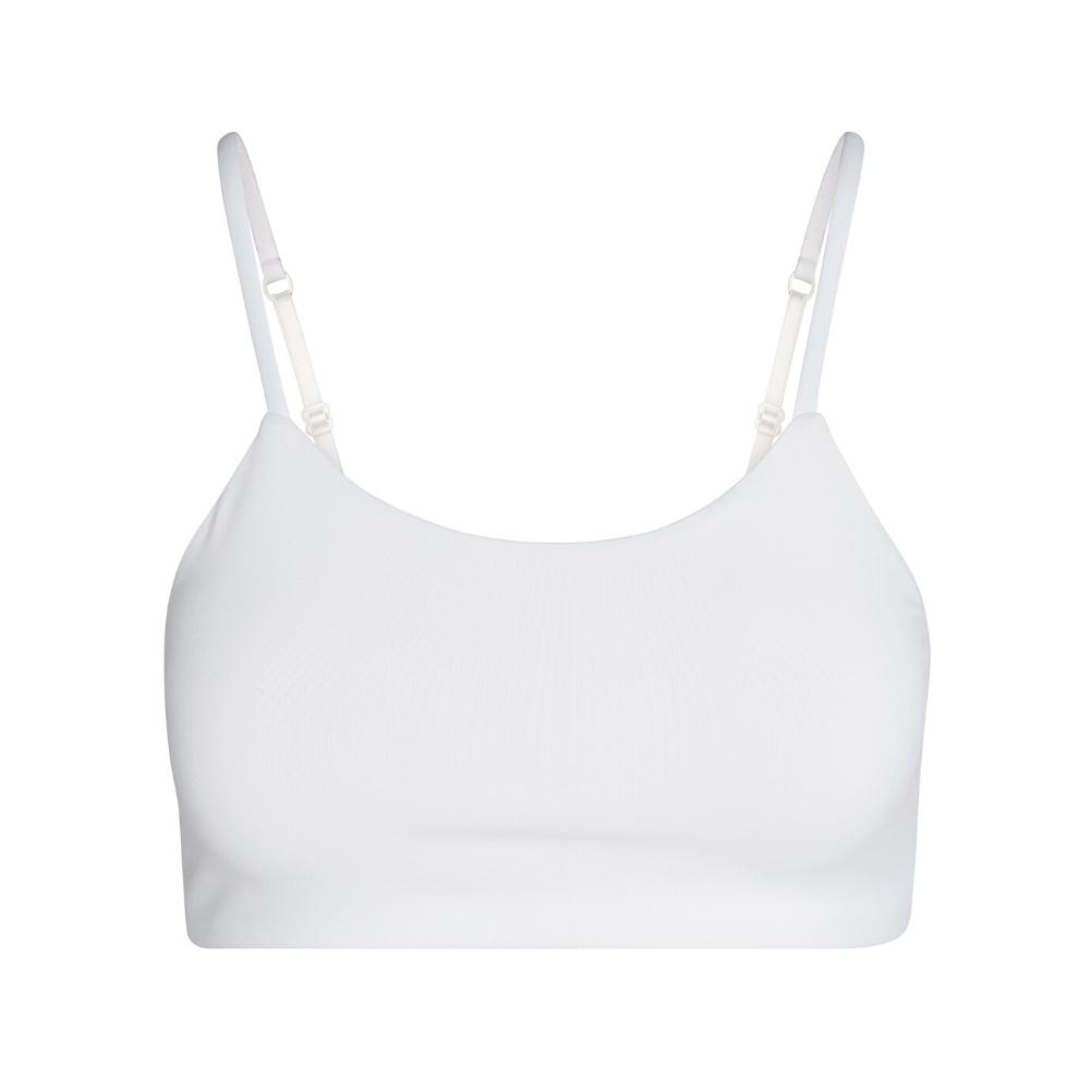 A white bra with adjustable straps, shown from the front.