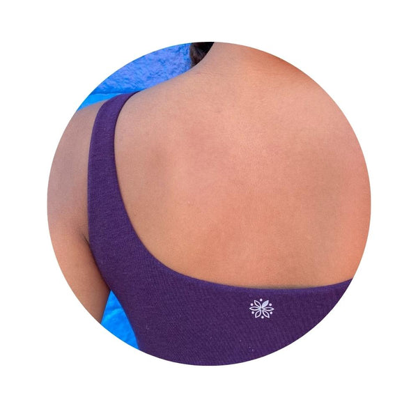 A young girl wearing a casual purple tank top (back view)